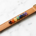 Seven chakra gemstone pet collar on white marble